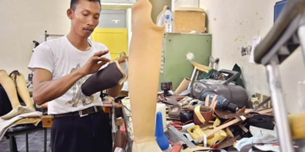 Pekerja difabel di Bengkel Prostetik dan Orthotik Yakkum Sleman sedang merakit kaki palsu untuk pasien rehabilitasi.